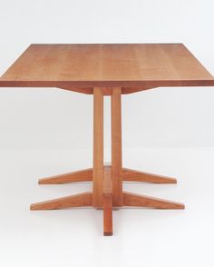 a square wooden table with four legs on the top and one leg raised up to the floor