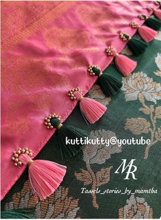 the tassels are attached to the pink and green fabric with gold beading