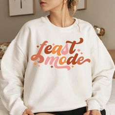 Get into the festive spirit with this Feast Mode Thanksgiving Sweatshirt. The cozy medium-heavy fabric blend and classic fit with crew neckline ensure a comfortable wearing experience. Perfect for those colder months, this sweatshirt is durable with double-needle stitching and features a tear-away label for itch-free wear. Ideal for Thanksgiving celebrations and anyone looking for a comfortable and festive holiday look. How to Order -Select size -Select Color, if you do not see a color available, please message seller -Add to Cart Product features - Cozy medium-heavy fabric blend of 50% cotton and 50% polyester - Classic fit with crew neckline for comfort - Double-needle stitching for durability - Tear-away label for itch-free wear - Ideal for Thanksgiving celebrations Care instructions - Cute Fall Sweater, Cute Sweaters For Fall, Feast Mode, Thanksgiving Sweatshirt, Thanksgiving Celebration, Autumn Harvest, Fall Sweater, Funny Thanksgiving, Holiday Looks