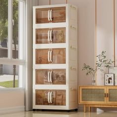 a white cabinet sitting next to a window in a living room with beige walls and flooring