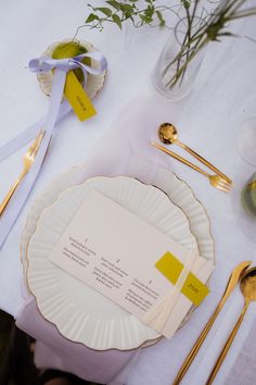 the place setting is set with yellow and white plates, silverware, and napkins