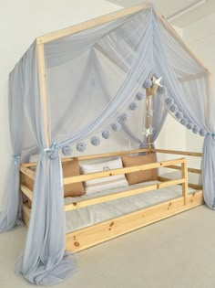 a bed with sheer curtains and pillows on it