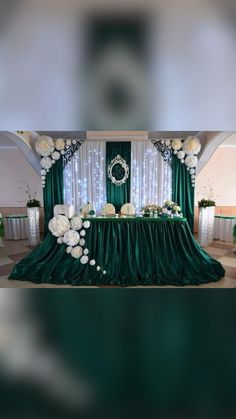 the table is set up with white flowers and greenery for an elegant wedding reception