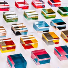 many different colored boxes sitting on top of a white table next to eachother