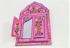 a pink mirror with flowers painted on it