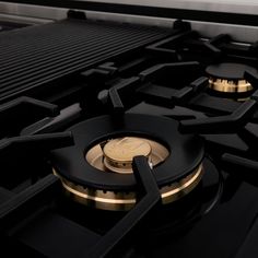 a close up view of the burners on a gas stove with gold trimmings