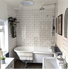 a bathroom with a tub, sink and mirror