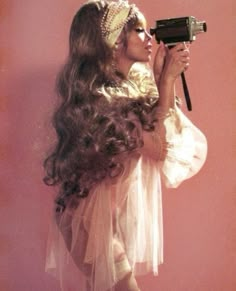 a woman with long hair holding a camera