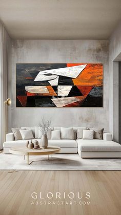 an abstract painting on the wall in a living room with white couches and coffee table