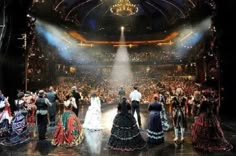 a group of people standing on top of a stage in front of a large crowd