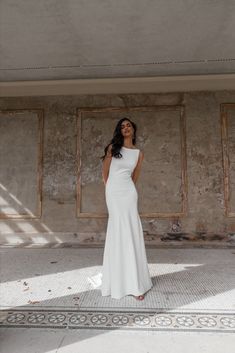 a woman in a white dress posing for the camera