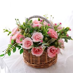 a basket filled with pink flowers on top of a white table