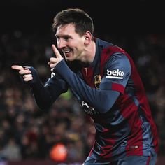 a soccer player is making the peace sign with his hand while standing in front of an audience