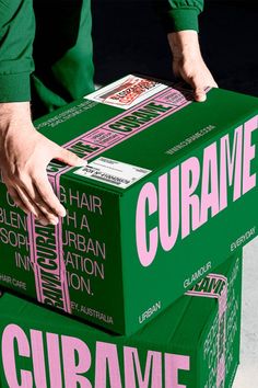 a person is holding two boxes that are stacked on top of each other, with the words curame printed on them