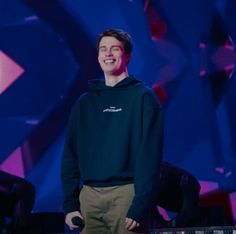 a young man standing in front of a keyboard