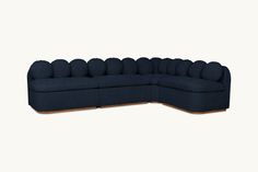 a blue sectional couch sitting on top of a white floor