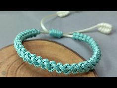 a close up of a bracelet on top of a piece of wood with the words diy macrame