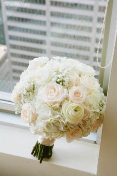 a bridal bouquet sitting on top of a window sill