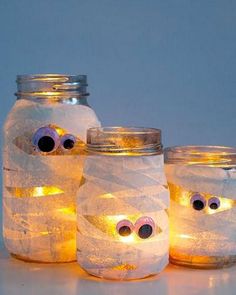 three mason jars with eyes and googly eyes on them