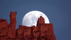 an image of a full moon in the sky over some rocks and mountains with text below it