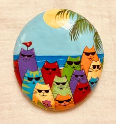 a button with many cats wearing sunglasses on it's face and palm tree in the background