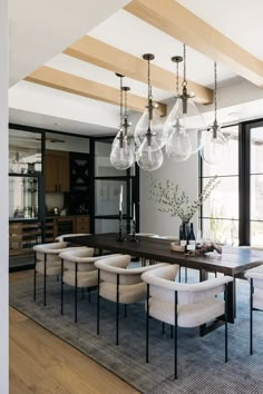 a large dining room table with chairs and chandelier hanging from the ceiling over it