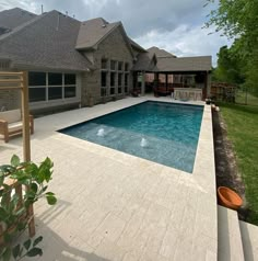 a backyard with a pool and patio furniture