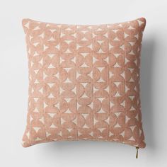 a pink and white pillow with geometric shapes on it