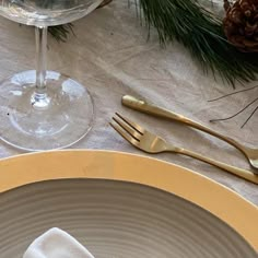 a place setting with silverware and pine cones