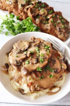 mashed potatoes with mushrooms and gravy in a white bowl