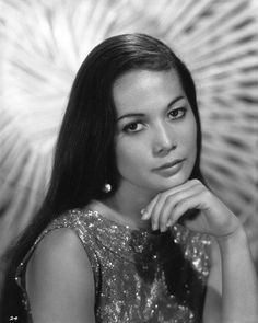 black and white photograph of a woman with long hair wearing a sparky dress looking at the camera