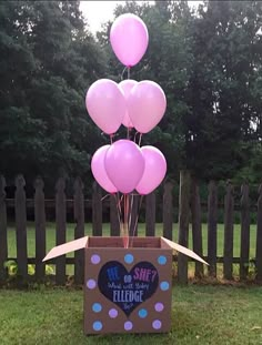 there is a box with balloons in the shape of a heart and some writing on it