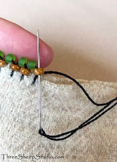 someone is stitching together some beads on a piece of fabric