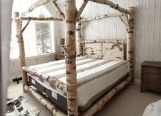 a bed made out of branches in a room with white walls and carpeted flooring