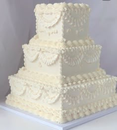 a three tiered white wedding cake on a table