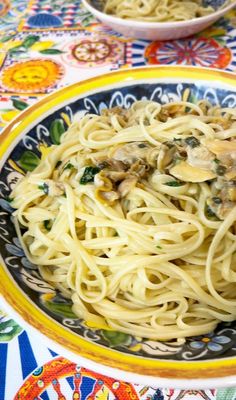 pasta with mushrooms and spinach in a bowl on a colorful tableclothed table cloth