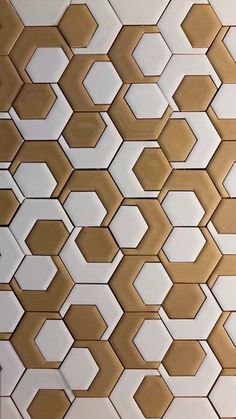 a white and gold tiled wall with hexagonal shapes