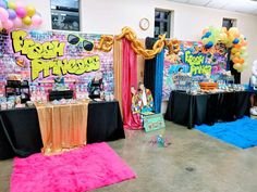 a room filled with lots of balloons and tables covered in decorations for a birthday party