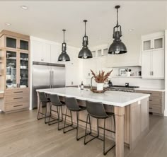 a large kitchen with an island in the middle and four chairs at the counter top