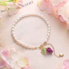 Intrigue your senses with the Grape Pearl Bracelet! Featuring a lovely enameled grape charm and a strand of lustrous pearls, this special design exudes charm, elegance, and a cheerful summer vibe. Embrace the enchanting fusion of classic beauty and playful charm, and let this exquisite piece adorn you with its timeless allure. Make a sophisticated style statement with this must-have accessory! Details Plating: 18K Gold Materials: 18K Gold on Brass, Enamel, Freshwater Pearls Size: Length: 6.69"(1 Grape Bracelet, Pearl Anklet, Fruit Jewelry, Style Statement, Pearl Size, Classic Beauty, Special Design, Sophisticated Style, Beaded Chain