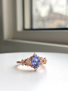 a tan and blue ring sitting on top of a white table next to a window