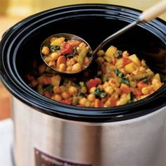 a slow cooker filled with corn and vegetables