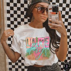 a woman taking a selfie in front of a black and white checkered wall