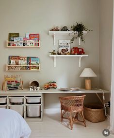 a bedroom with white walls and shelves filled with children's books, toys and other items