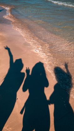 the shadow of two people standing in front of an ocean