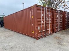 two large brown shipping containers sitting next to each other on top of a parking lot