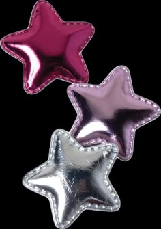 three shiny star shaped foil balloons in different colors and sizes, one is pink, the other is silver