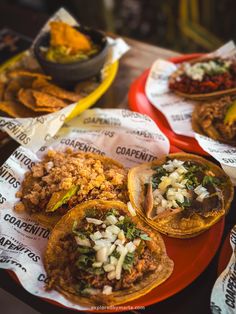 some tacos and other food on a red plate