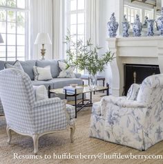 a living room filled with furniture and a fire place in front of a fireplace covered in blue and white vases