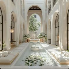 an indoor courtyard with white flowers and greenery on the floor, surrounded by arched windows